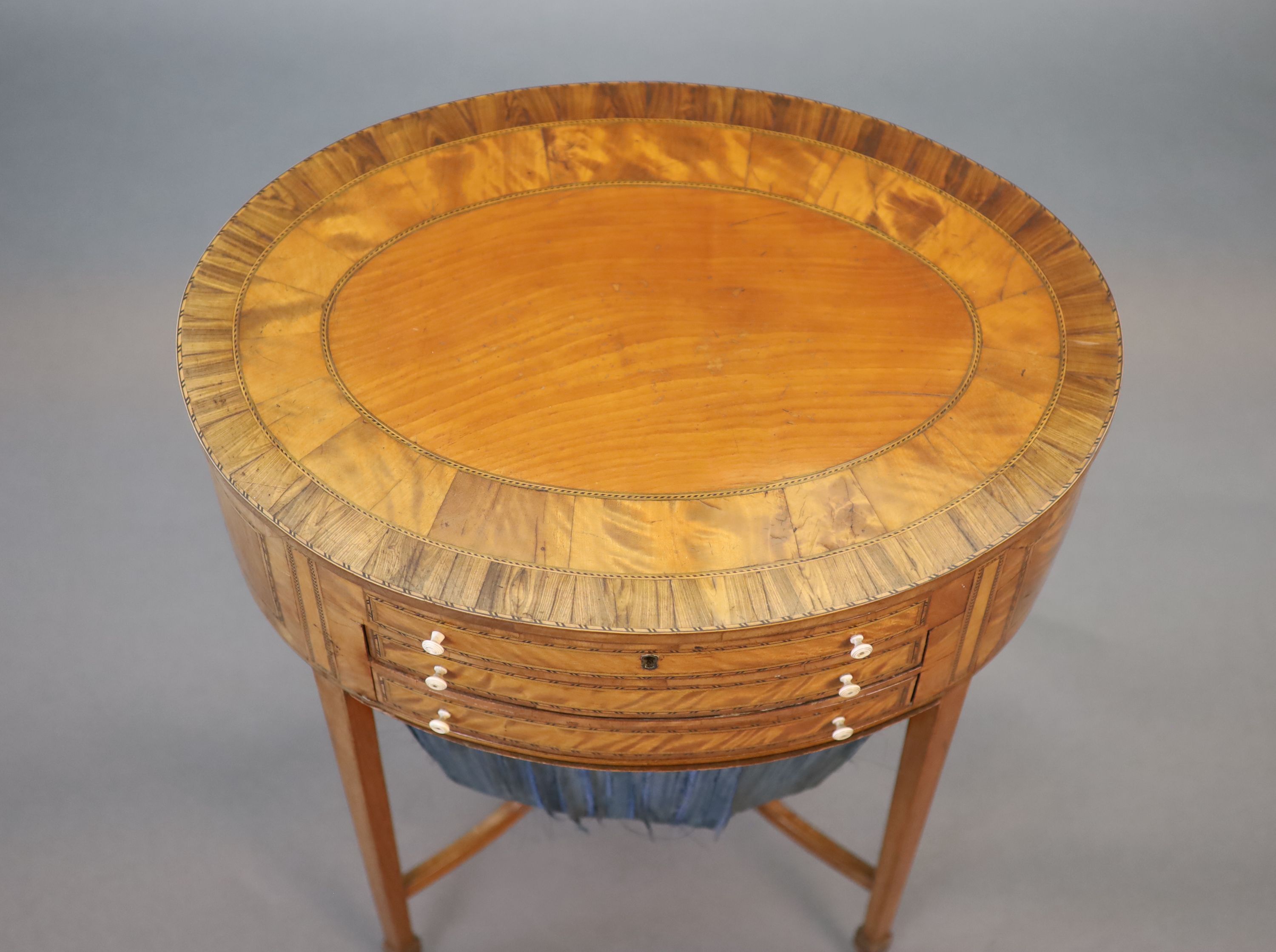 A George III rosewood banded satinwood oval work table, W.54.5cm D.39cm H.70cm